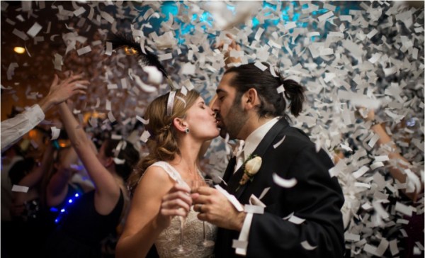 Magical Wedding Kiss Amidst White Confetti and Magical Blue and Orange Lighting