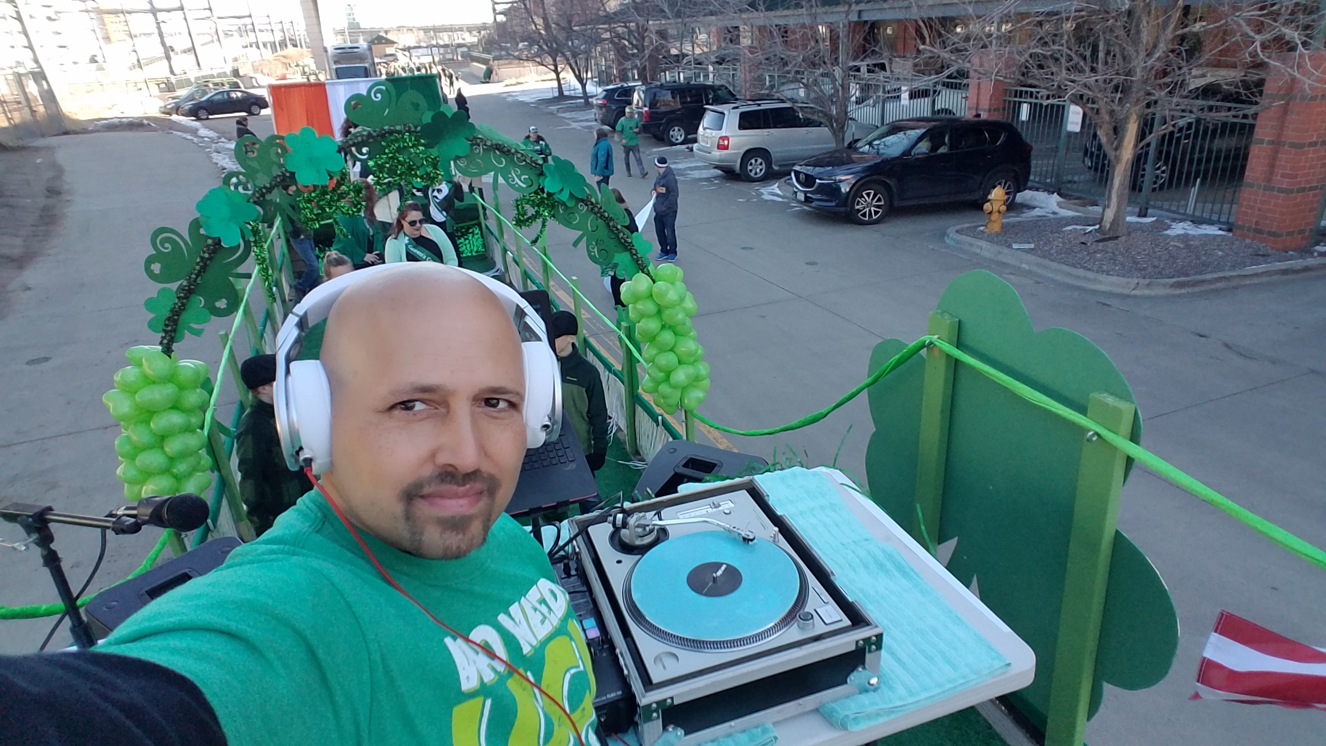 DJ Emir of Denver's best DJs on the First Float Committee Float of the St Patrick's Day Parade with full technics turntable set up and neon green glow in the dark Serato records